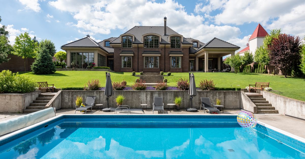 Elegant mansion with a sparkling pool and well-maintained garden, ideal for luxury living.